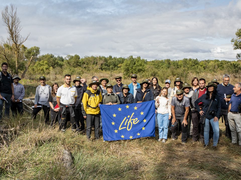 Grupo de trabajo del LIFE Ebro Resilience P1 con la bandera del Programa LIFE en una visita al Soto de Tamarigal
