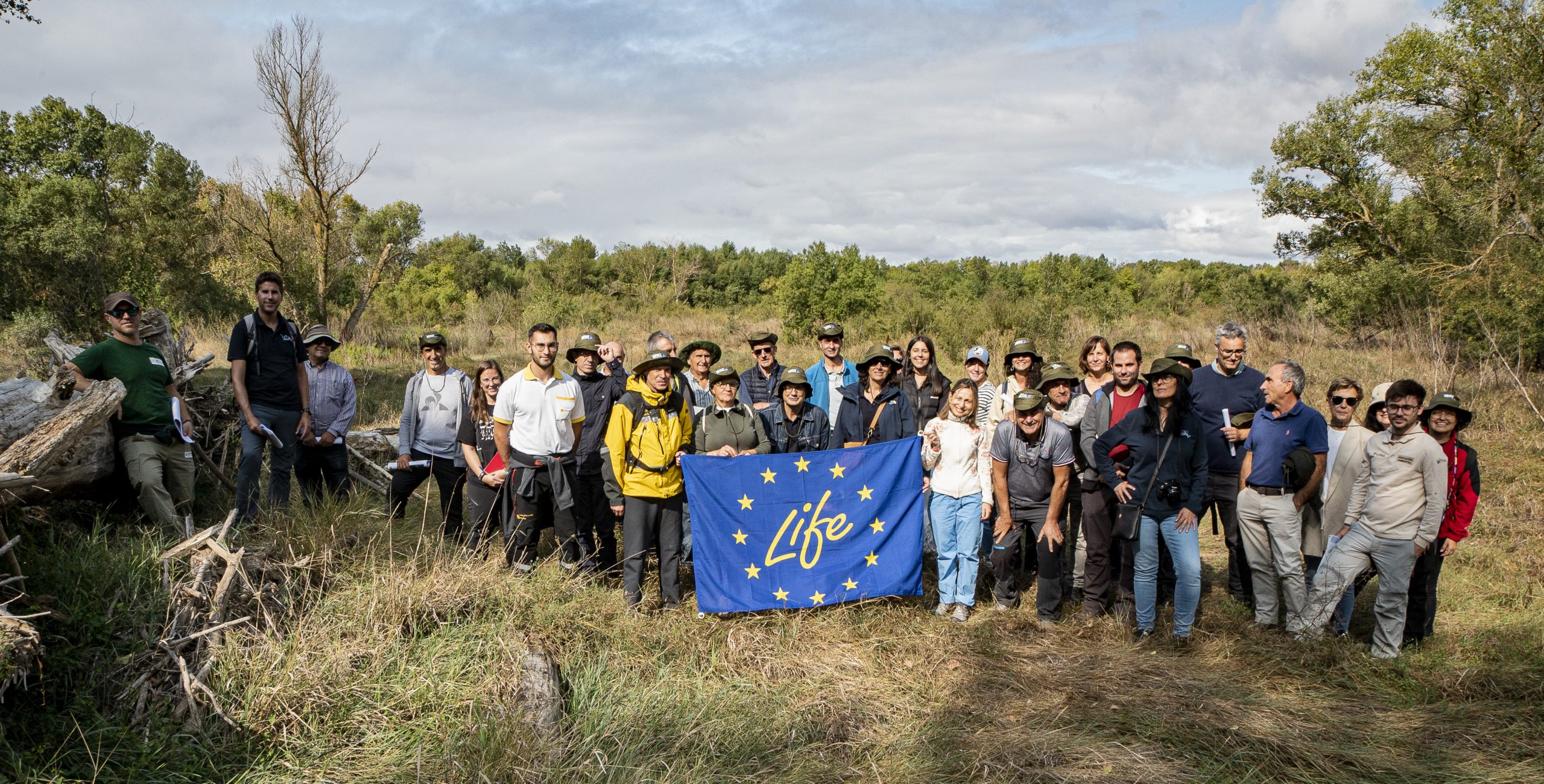 Grupo de trabajo del LIFE Ebro Resilience P1 con la bandera del Programa LIFE en una visita al Soto de Tamarigal
