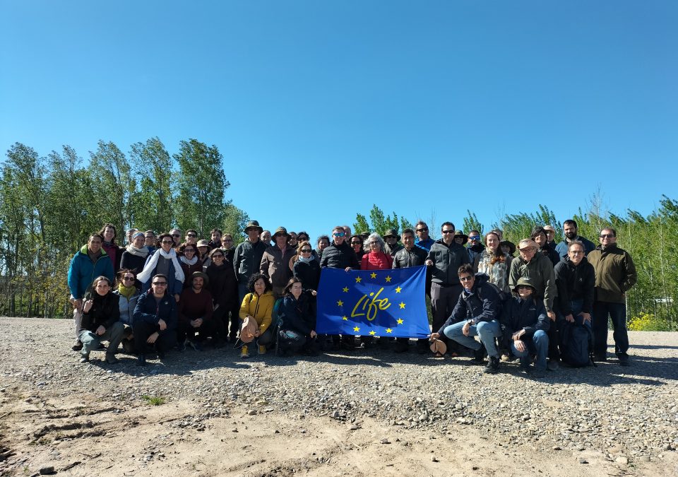 Foto de grupo con bandera LIFE visita Organismos de cuenca de toda España al meandro de La Roza, Alfaro.