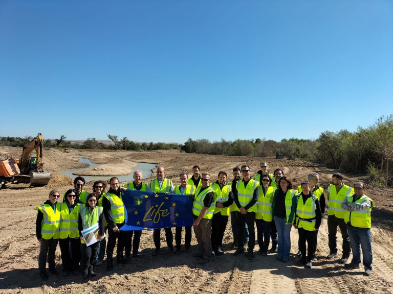 Visita de Federico de Filippi. Foto de familia con bandera con humedal en Fuentes de Ebro.