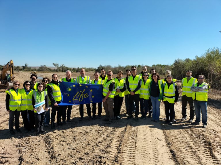 Visita de Federico de Filippi. Foto de familia con bandera con humedal en Fuentes de Ebro. 2